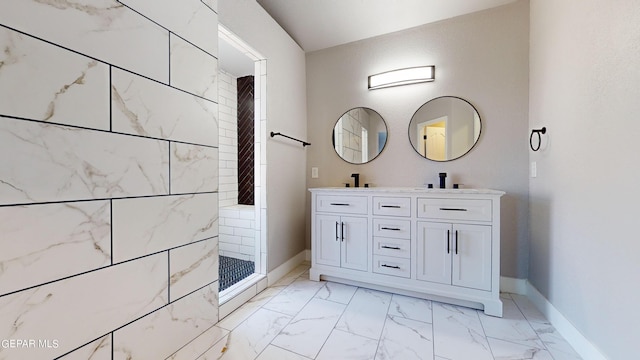 bathroom featuring tiled shower and vanity