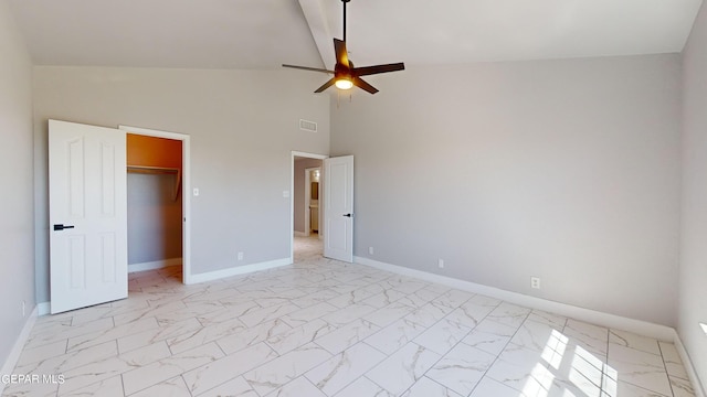 unfurnished bedroom with ceiling fan, a closet, a spacious closet, and high vaulted ceiling