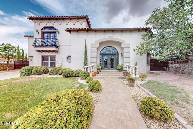 mediterranean / spanish-style home featuring french doors and a front lawn