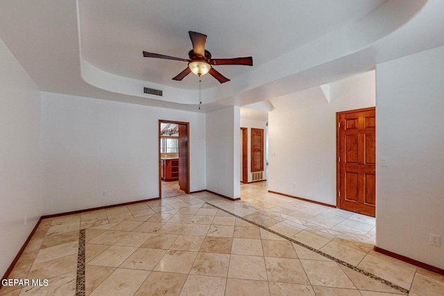 unfurnished room with a tray ceiling and ceiling fan