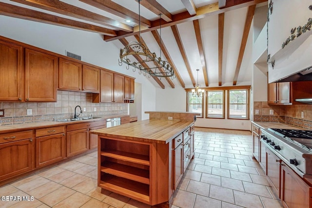 kitchen featuring beam ceiling, tasteful backsplash, a kitchen island, wood counters, and sink