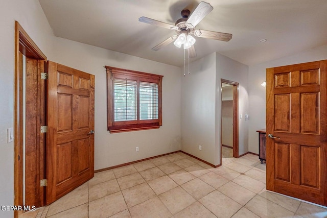 unfurnished bedroom with a spacious closet, light tile patterned flooring, a closet, and ceiling fan