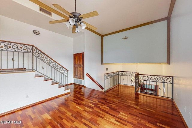 unfurnished living room featuring crown molding, wood-type flooring, and ceiling fan