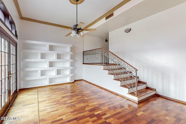 unfurnished living room with crown molding, french doors, wood-type flooring, and ceiling fan