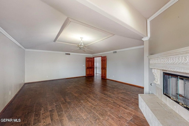 unfurnished living room featuring ceiling fan, ornamental molding, a tile fireplace, and hardwood / wood-style floors