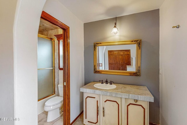 full bathroom featuring vanity, shower / bath combination with glass door, toilet, and tile patterned floors