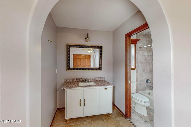 full bathroom featuring vanity, toilet, tiled shower / bath combo, and tile patterned flooring