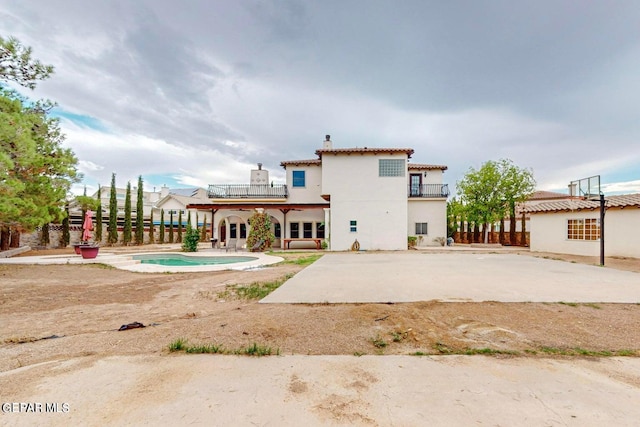 rear view of house featuring a patio and a balcony