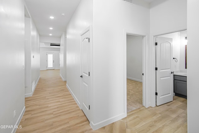 hallway with light hardwood / wood-style floors