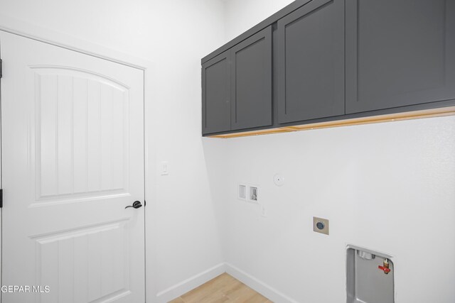 laundry room featuring hookup for a washing machine, hookup for an electric dryer, gas dryer hookup, light hardwood / wood-style floors, and cabinets