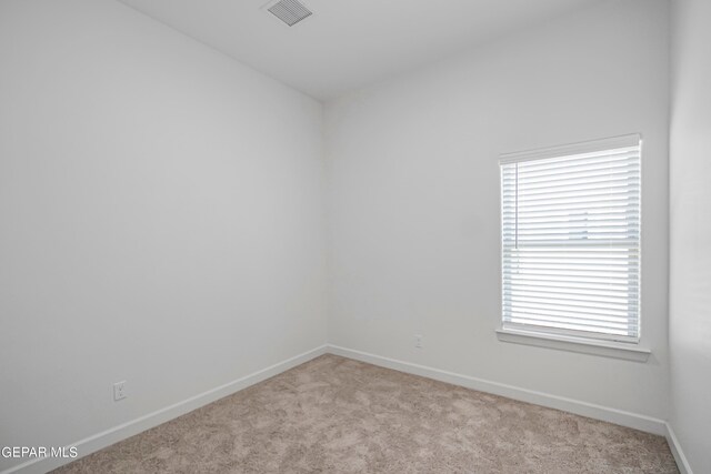 unfurnished room featuring light carpet