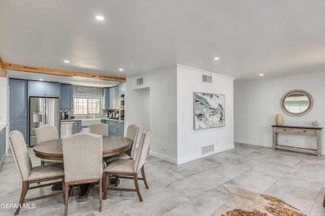 dining area with ornamental molding and sink