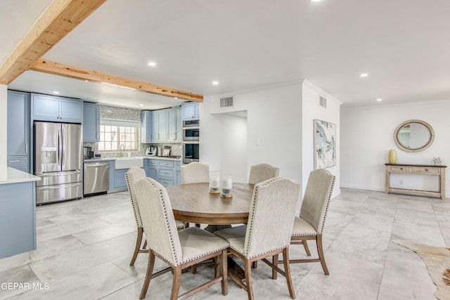 dining room with beam ceiling, crown molding, sink, and light tile patterned floors