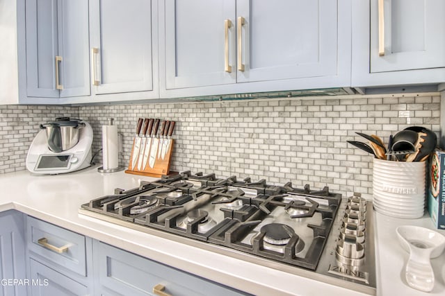 details with stainless steel gas stovetop and tasteful backsplash