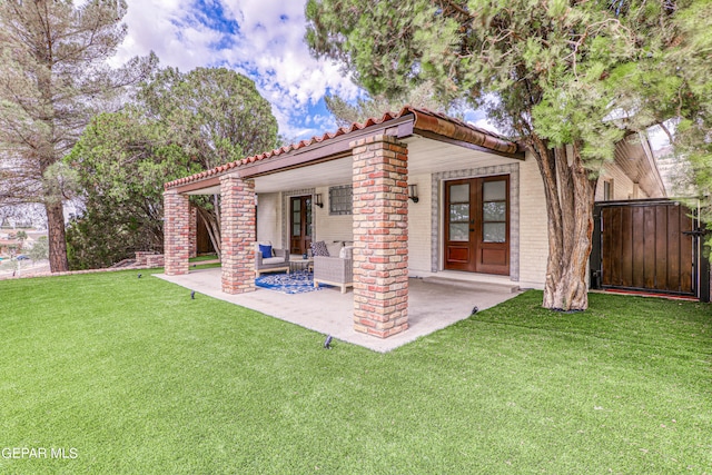 rear view of house featuring a patio area and a lawn