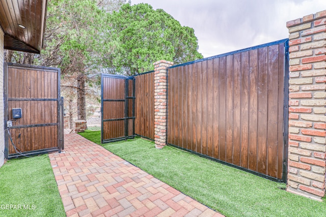 view of gate featuring a lawn