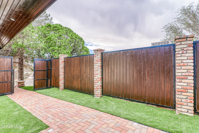 view of gate with a yard