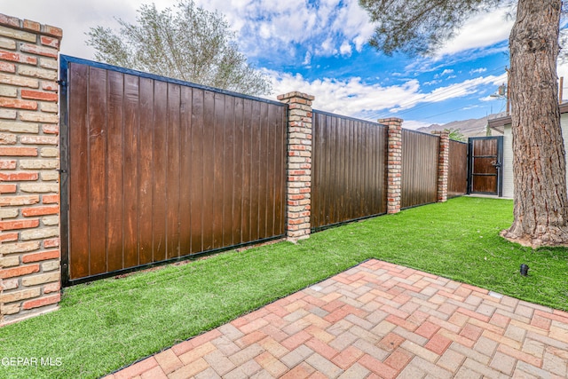 view of gate with a yard