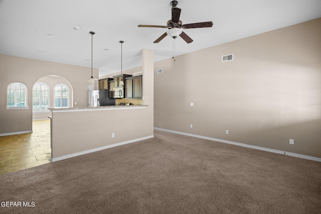 unfurnished living room with ceiling fan and carpet flooring