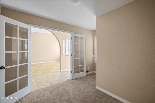 carpeted empty room with french doors