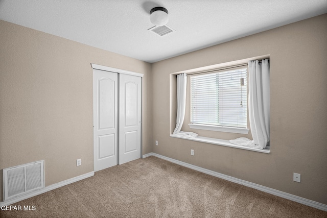 unfurnished bedroom with carpet floors and a closet