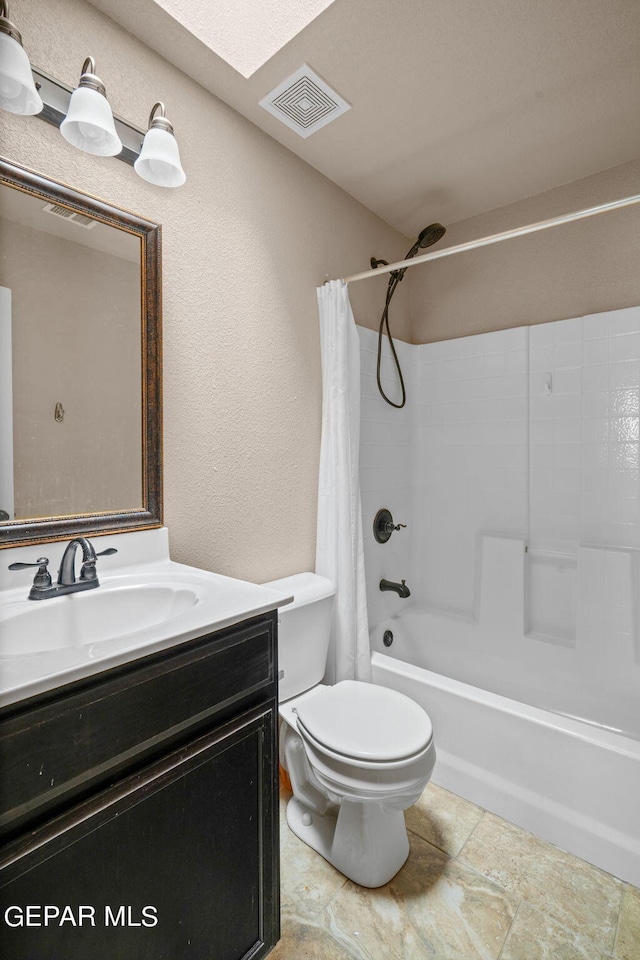 full bathroom featuring toilet, shower / bath combo with shower curtain, vanity, and a skylight