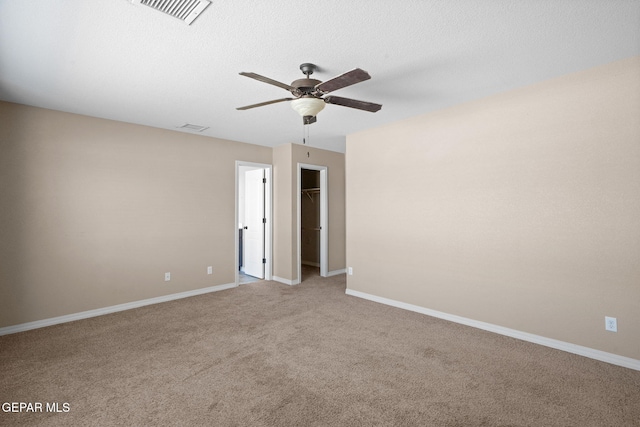 empty room featuring light carpet, a textured ceiling, and ceiling fan