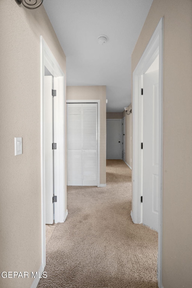 hallway featuring light colored carpet