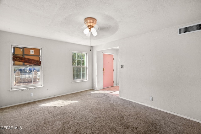 carpeted spare room featuring ceiling fan and a textured ceiling