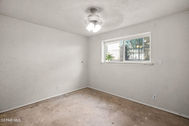 spare room featuring concrete floors, a textured ceiling, and ceiling fan