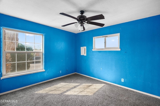 carpeted spare room with a textured ceiling and ceiling fan