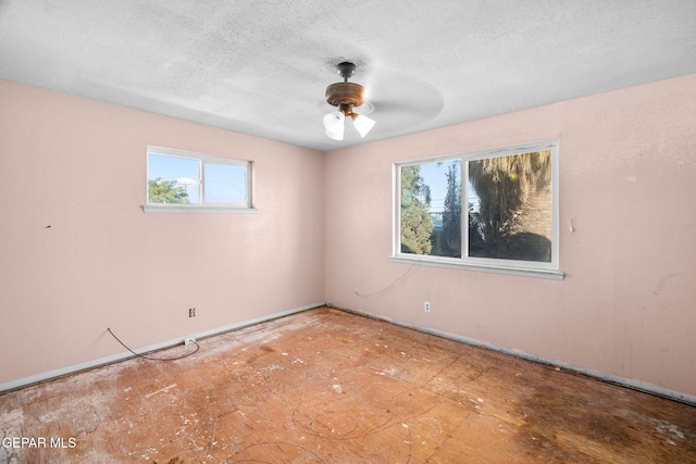 empty room with a textured ceiling and ceiling fan