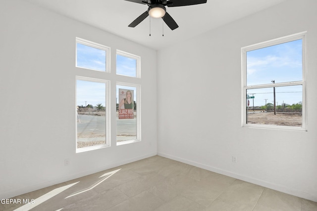 tiled spare room with ceiling fan