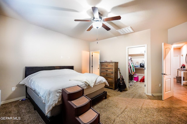 bedroom featuring a closet, ceiling fan, carpet floors, and a walk in closet