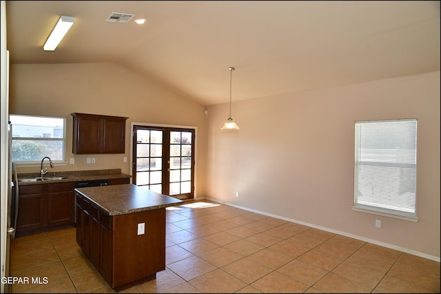 kitchen with decorative light fixtures, a kitchen island, a healthy amount of sunlight, and vaulted ceiling