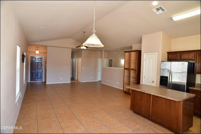 kitchen with stainless steel refrigerator with ice dispenser, vaulted ceiling, ceiling fan, light tile patterned floors, and hanging light fixtures