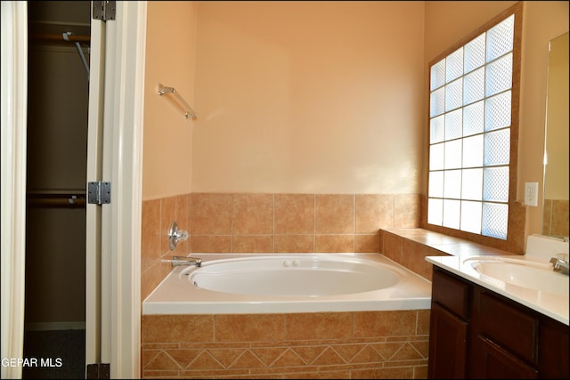 bathroom with vanity and a relaxing tiled tub