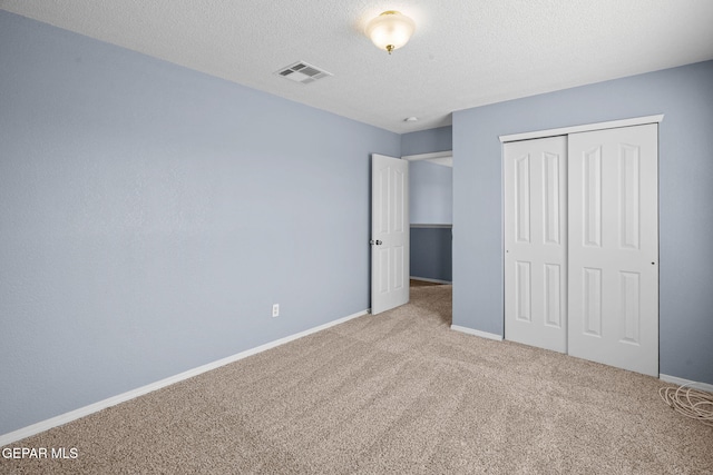 unfurnished bedroom with a closet, carpet floors, and a textured ceiling