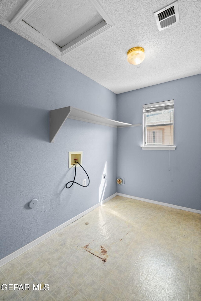 laundry room with a textured ceiling and washer hookup