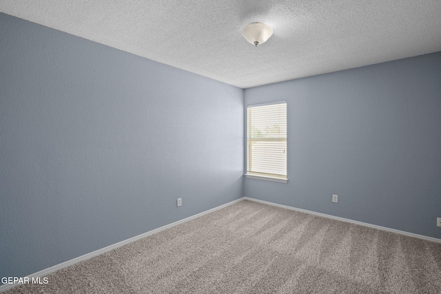 carpeted empty room featuring a textured ceiling