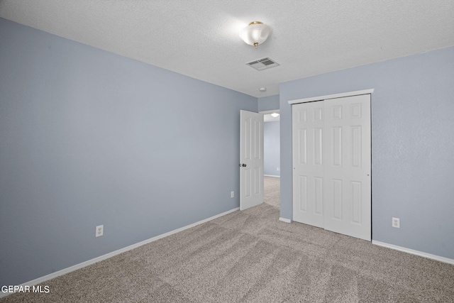 unfurnished bedroom featuring a closet, carpet floors, and a textured ceiling