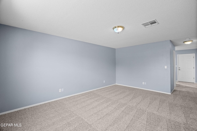 carpeted spare room featuring a textured ceiling