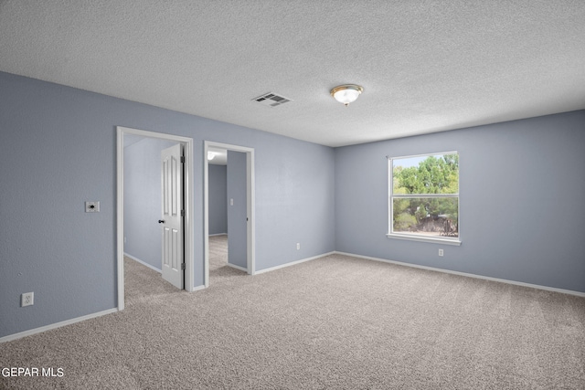 carpeted spare room featuring a textured ceiling