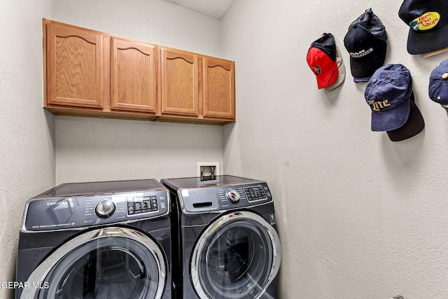 laundry room with washing machine and dryer and cabinets