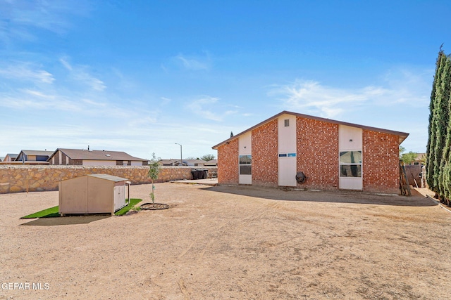 rear view of house with a storage shed