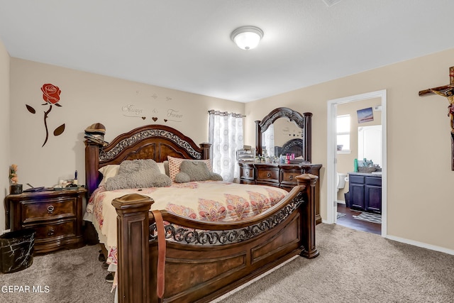 bedroom with dark carpet and ensuite bath