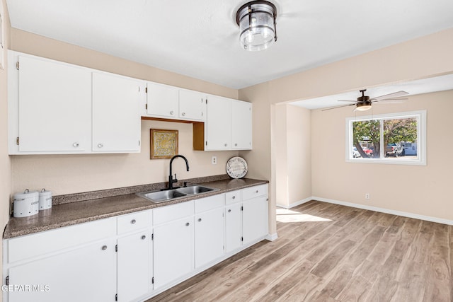 kitchen featuring sink, white cabinetry, light wood-type flooring, and ceiling fan