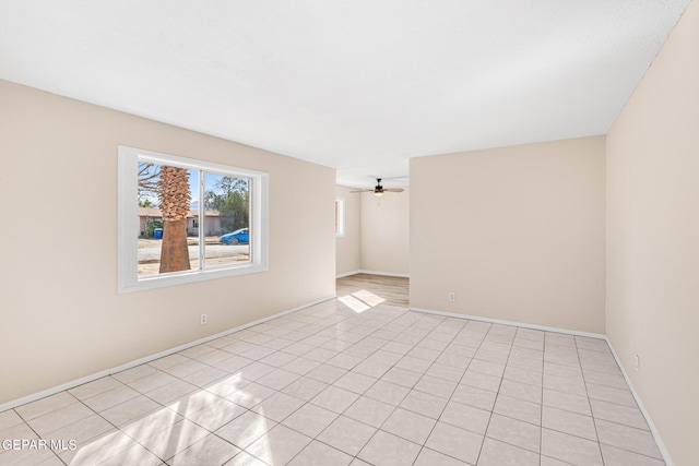 tiled empty room featuring ceiling fan