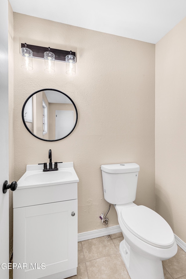 bathroom featuring toilet, vanity, and tile patterned flooring