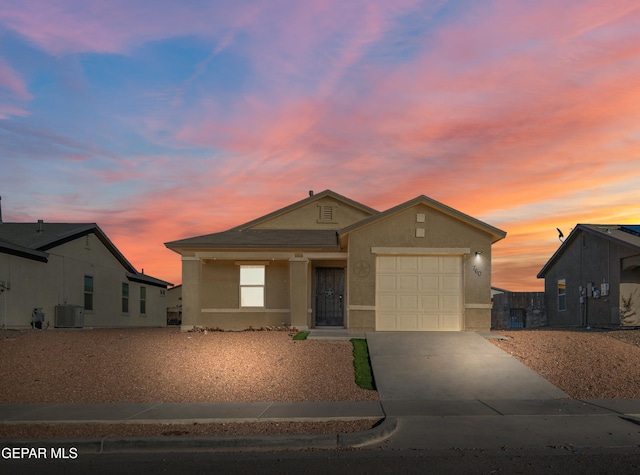 view of front of property with a garage and central AC